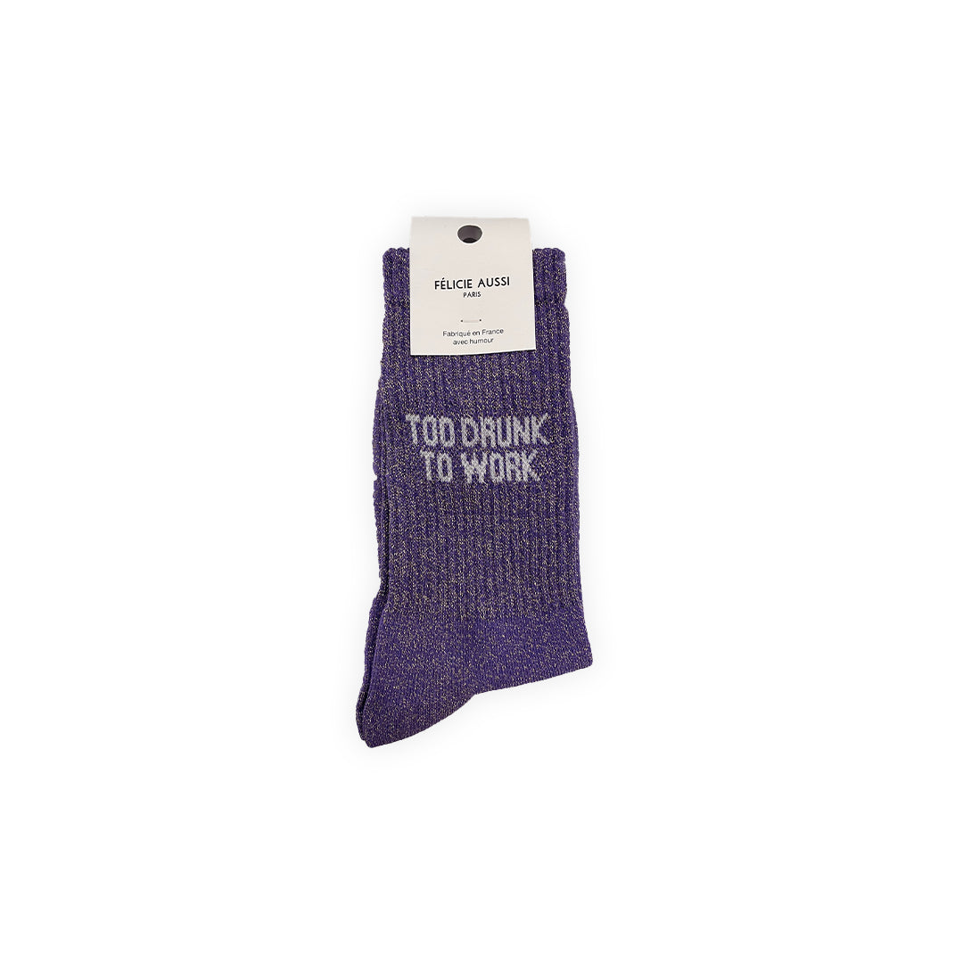 Paire de chaussettes à paillettes couleur mauve avec lettrage blanc : "Too drunk to work"