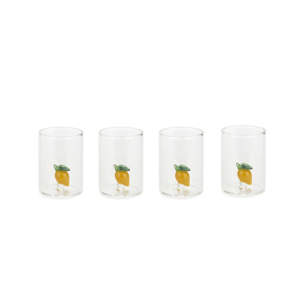 Set de quatre petits verres à shot en verre transparent, chacun contenant à l’intérieur une petite figurine de citron jaune décorative.
